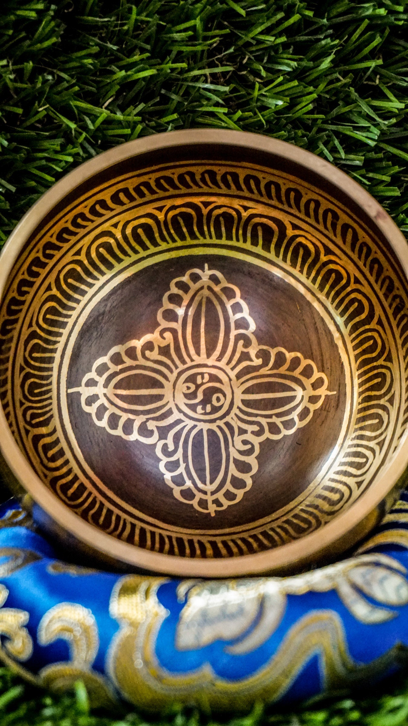 The Double Dorje Singing Bowl grounds and centers your energy. At its heart is the double dorje symbol, representing protection, balance, and spiritual strength. The outside is wrapped with the Om Mani Padme Hum mantra, adding compassion and focus. It produces deep, steady tones perfect for grounding meditation or creating calm. Includes singing bowl, wooden mallet, and silk cushion. Wipe clean and store dry. Let this bowl be your anchor for stillness and strength.