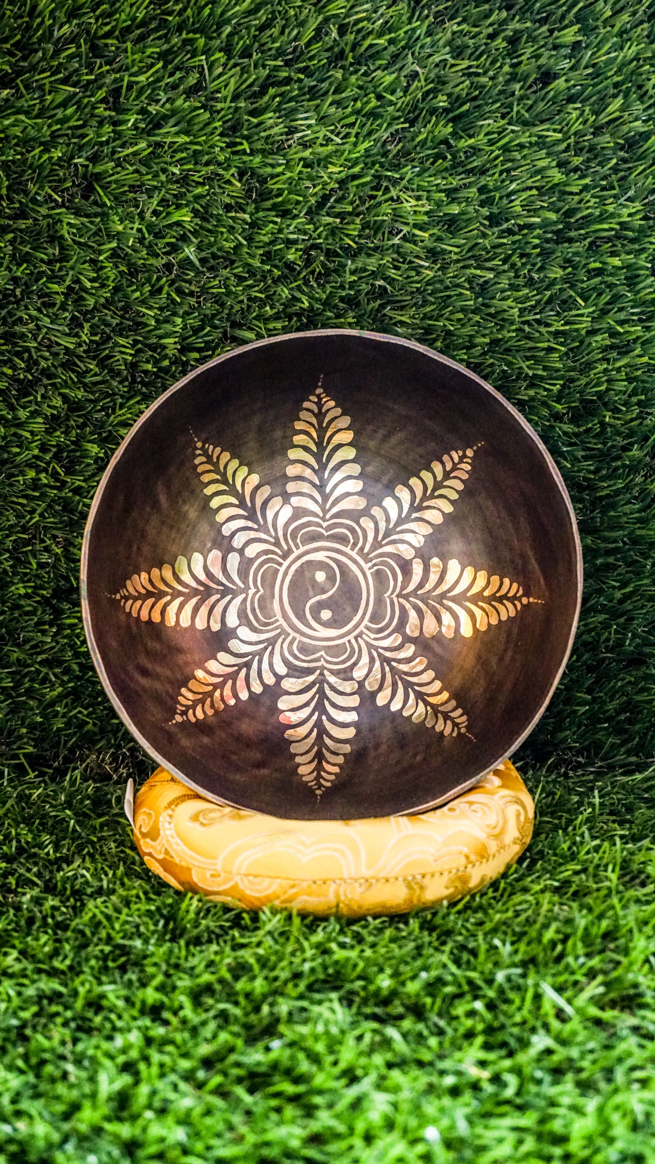 The Yin Yang Singing Bowl features the Yin Yang symbol inside a floral mandala with flower patterns outside. Its gentle sound brings calm and balance, perfect for meditation or peaceful spaces.