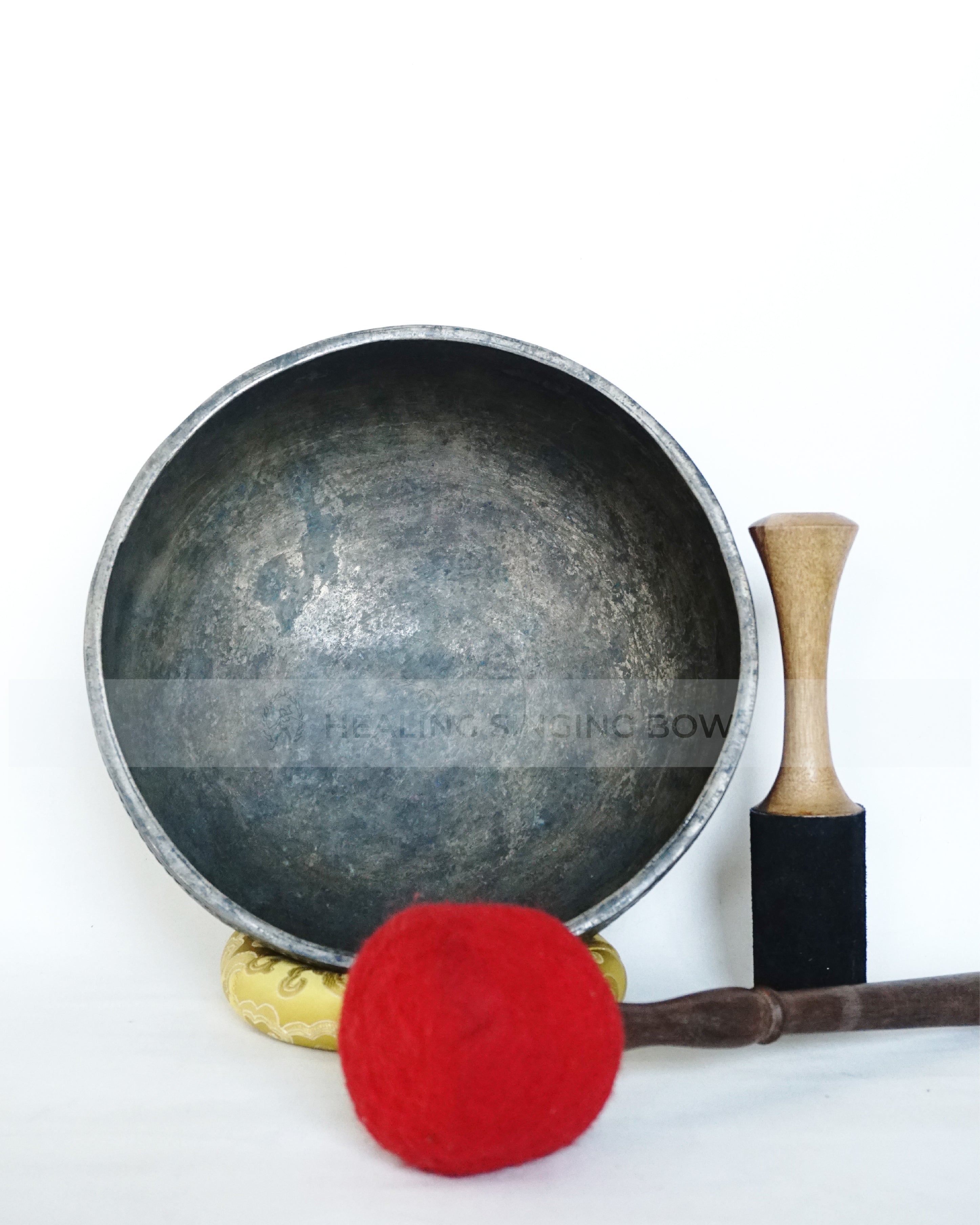 Large hand-hammered Tibetan singing bowl with a 24.5 cm diameter, shown from the top view and placed on a decorative cushion against a white background.