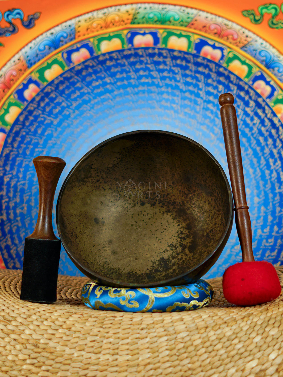 Semi antique Tibetan singing bowl handmade in Nepal with aged bronze finish on a traditional blue cushion
