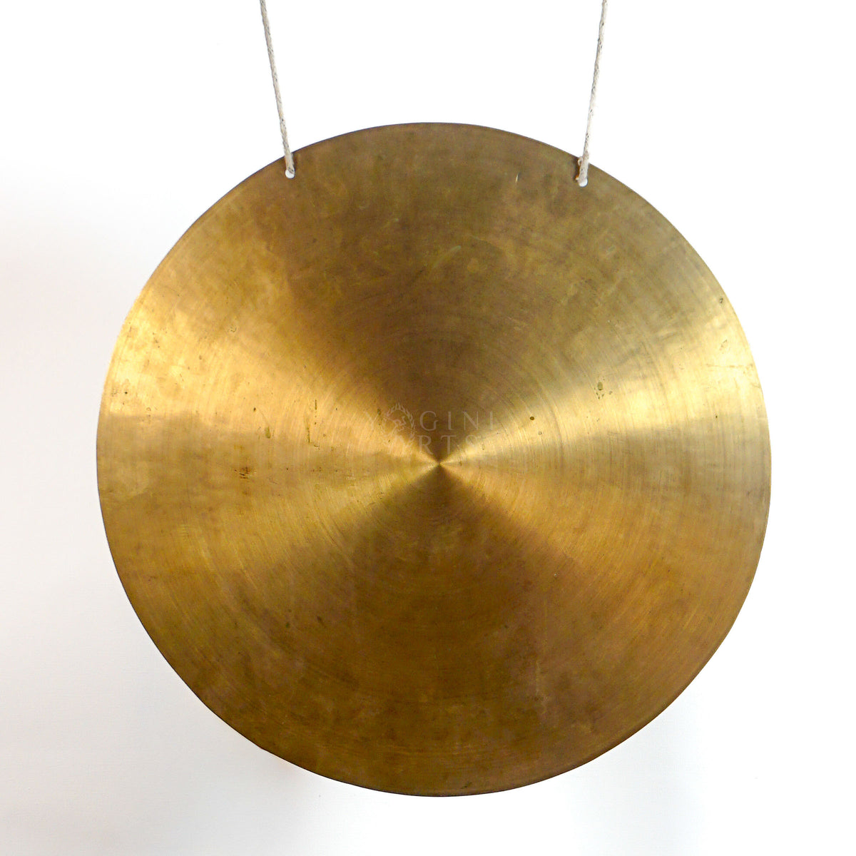 Close-up of a handmade Tibetan-style gong showing the antique gold metal surface, circular form, and fine radial texture.