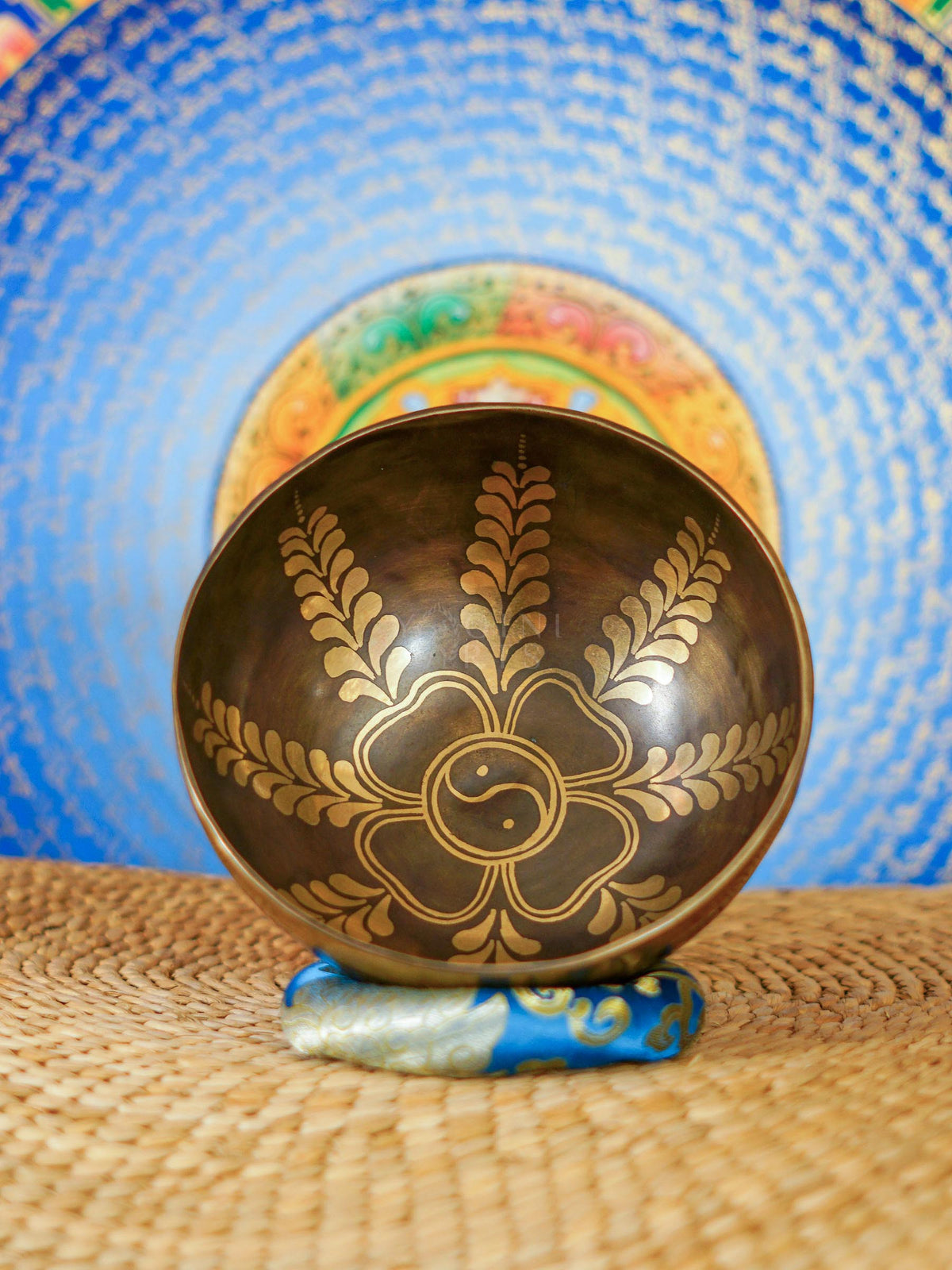 Handcrafted Yin Yang singing bowl from Nepal with floral engraving and bronze-gold finish for meditation and sound practice.