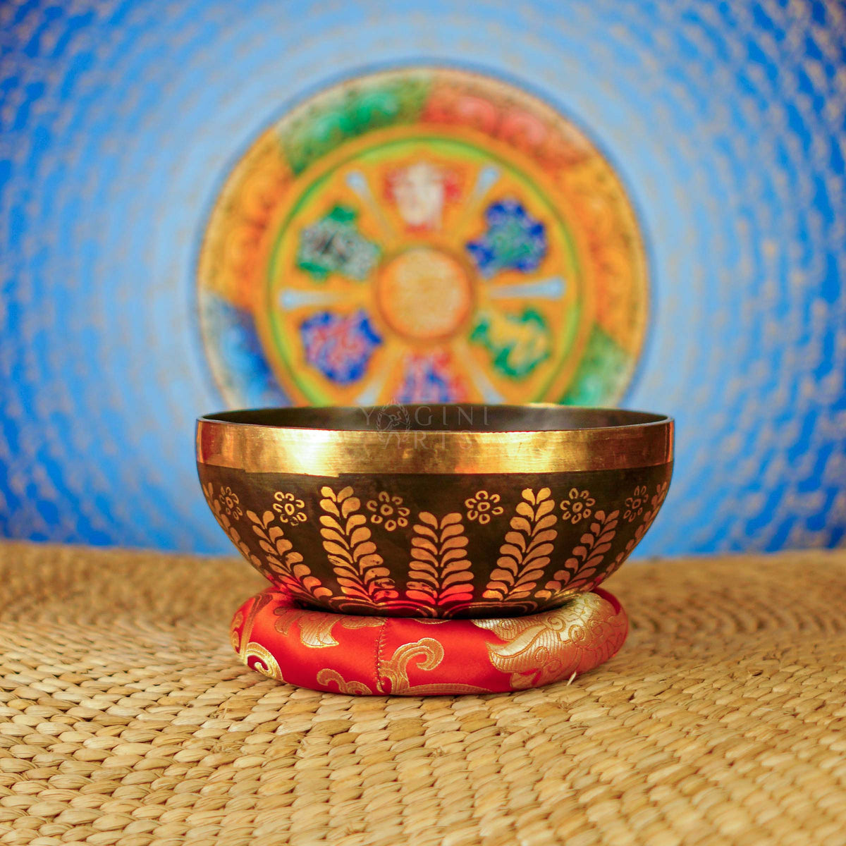 Handcrafted Yin Yang singing bowl from Nepal with gold floral engraving, dark bronze finish, decorative cushion and wooden striker.