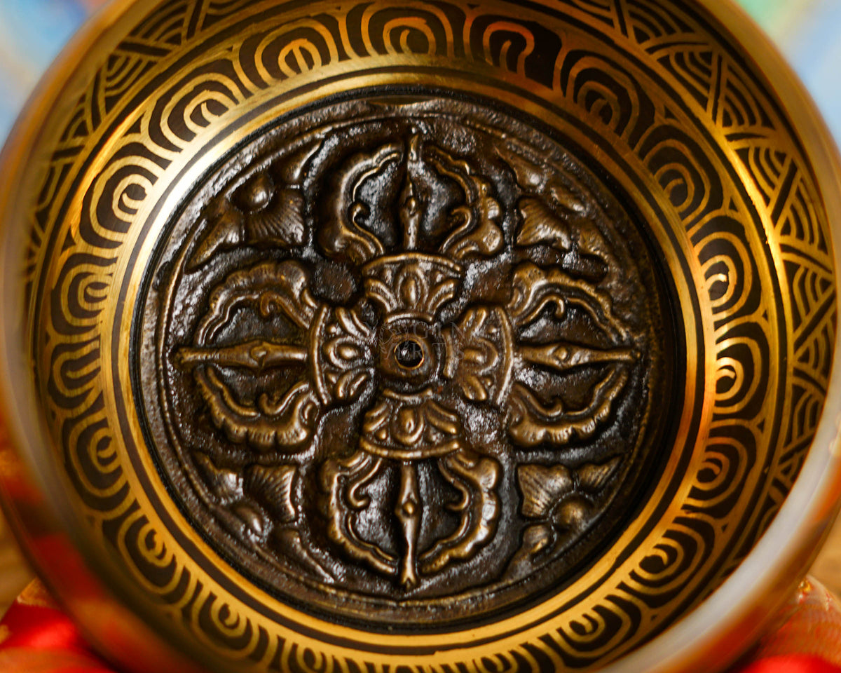 Close-up of a handcrafted Dorje design singing bowl featuring traditional Himalayan Buddhist engraving