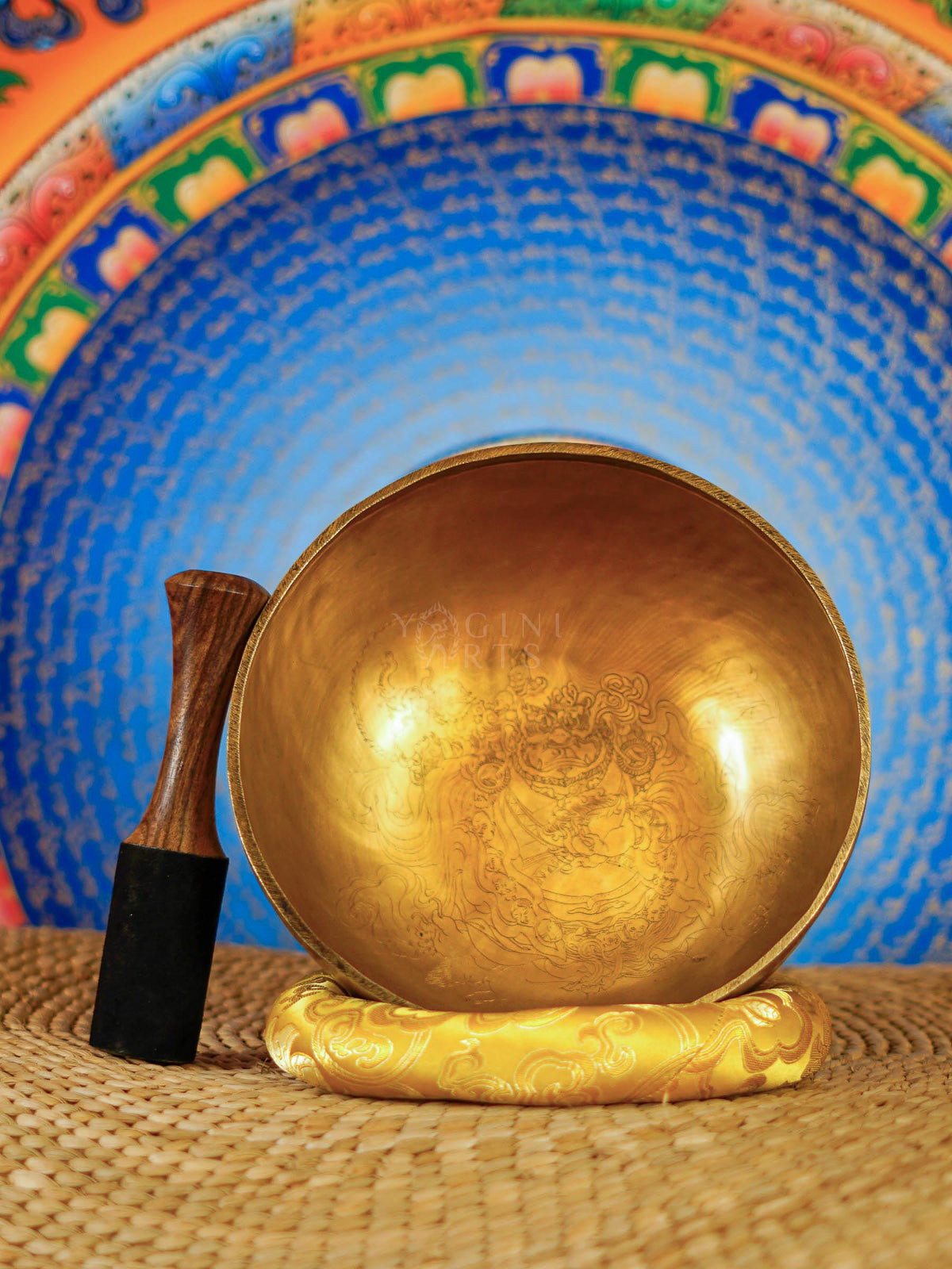 Mahakala Tibetan singing bowl with engraved deity design and yellow cushion