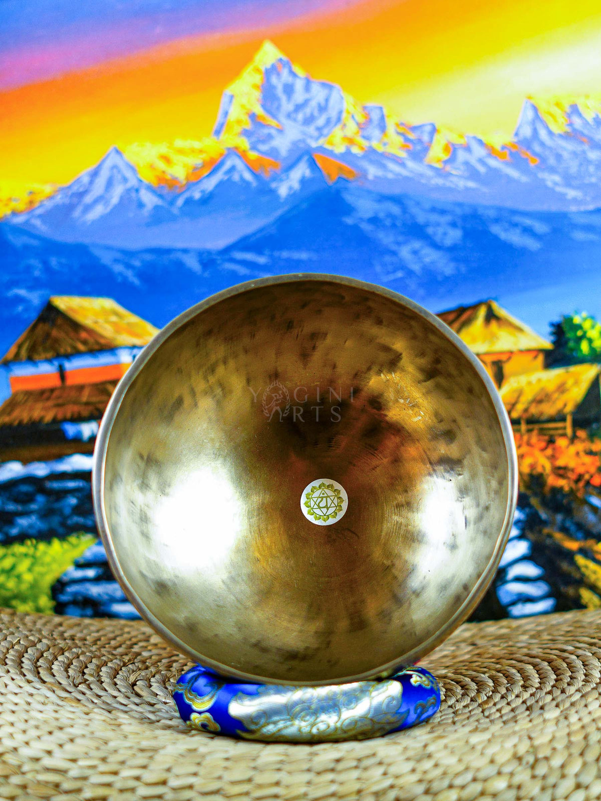 Himalayan singing bowl set displayed with wooden mallets and decorative cushions for meditation and sound practice.