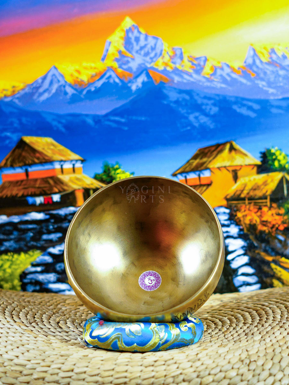 Himalayan singing bowl set displayed with wooden mallets and decorative cushions for meditation and sound practice.