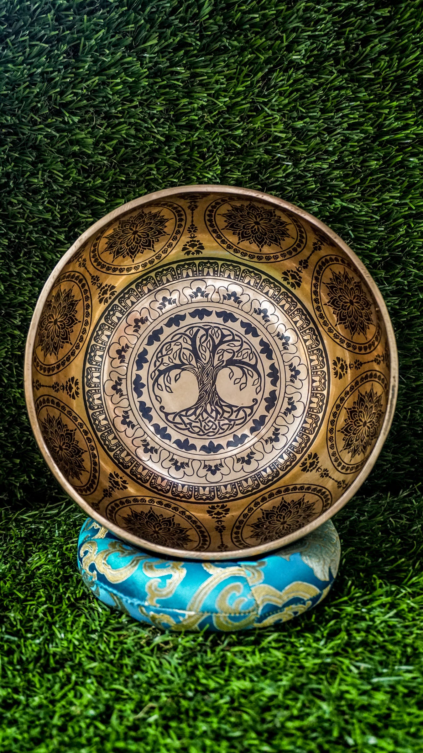 Handcrafted Tree of Life singing bowl featuring a central tree design, surrounding motif and floral patterns inside, and repeated Tree of Life engravings on the outside; includes wooden mallet and silk cushion, ideal for meditation and grounding.