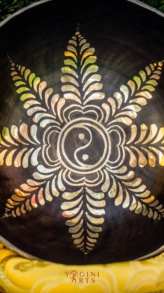 The Yin Yang Singing Bowl features the Yin Yang symbol inside a floral mandala with flower patterns outside. Its gentle sound brings calm and balance, perfect for meditation or peaceful spaces.