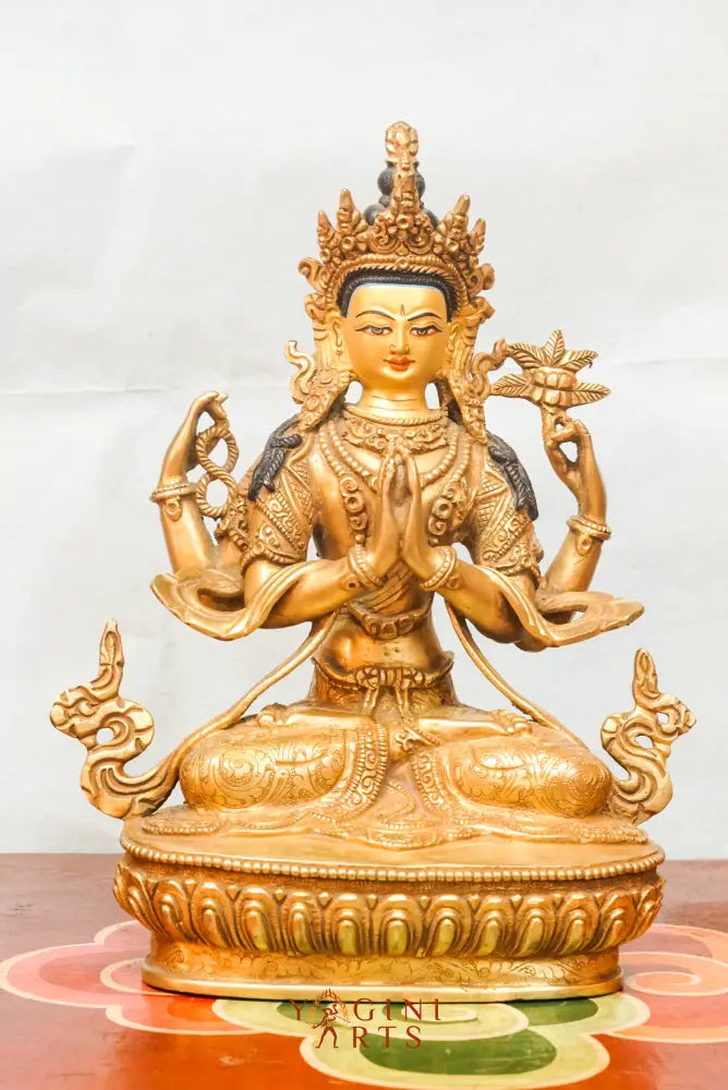 Gold-plated statue of Chengresi (Chenrezig), the Tibetan Buddhist deity of compassion, depicted with four arms in a meditative posture, adorned with ornate jewelry and a serene facial expression.