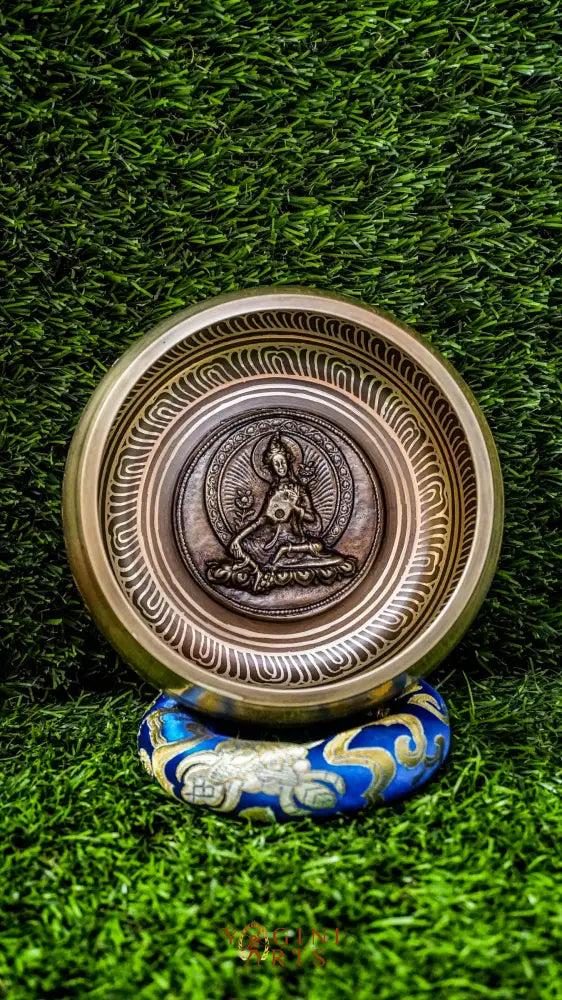 A beautifully carved singing bowl featuring the Green Tara deity at its center, surrounded by Om Mani Padme Hum inscriptions. This bowl produces a rich, resonant tone that supports meditation and spiritual practice. Green Tara symbolizes compassion, swift healing, and protection. Ideal for deepening your meditation practice, enhancing your altar space, or creating moments of inner peace and clarity.