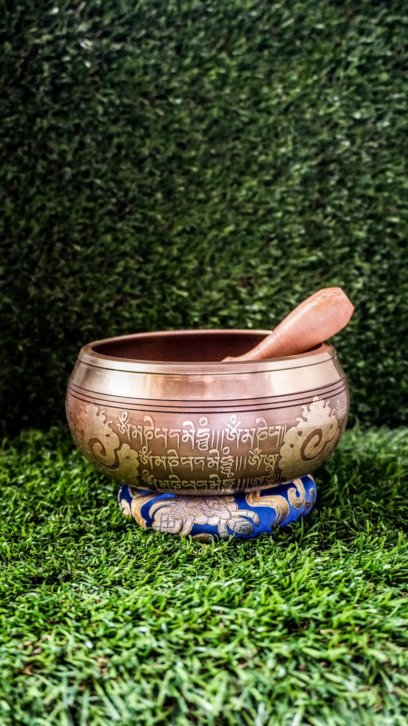 Bronze singing bowl with a carved meditating Buddha at the center, surrounded by the Om Mani Padme Hum mantra inside and engraved again around the outside, radiating peaceful, grounding energy.