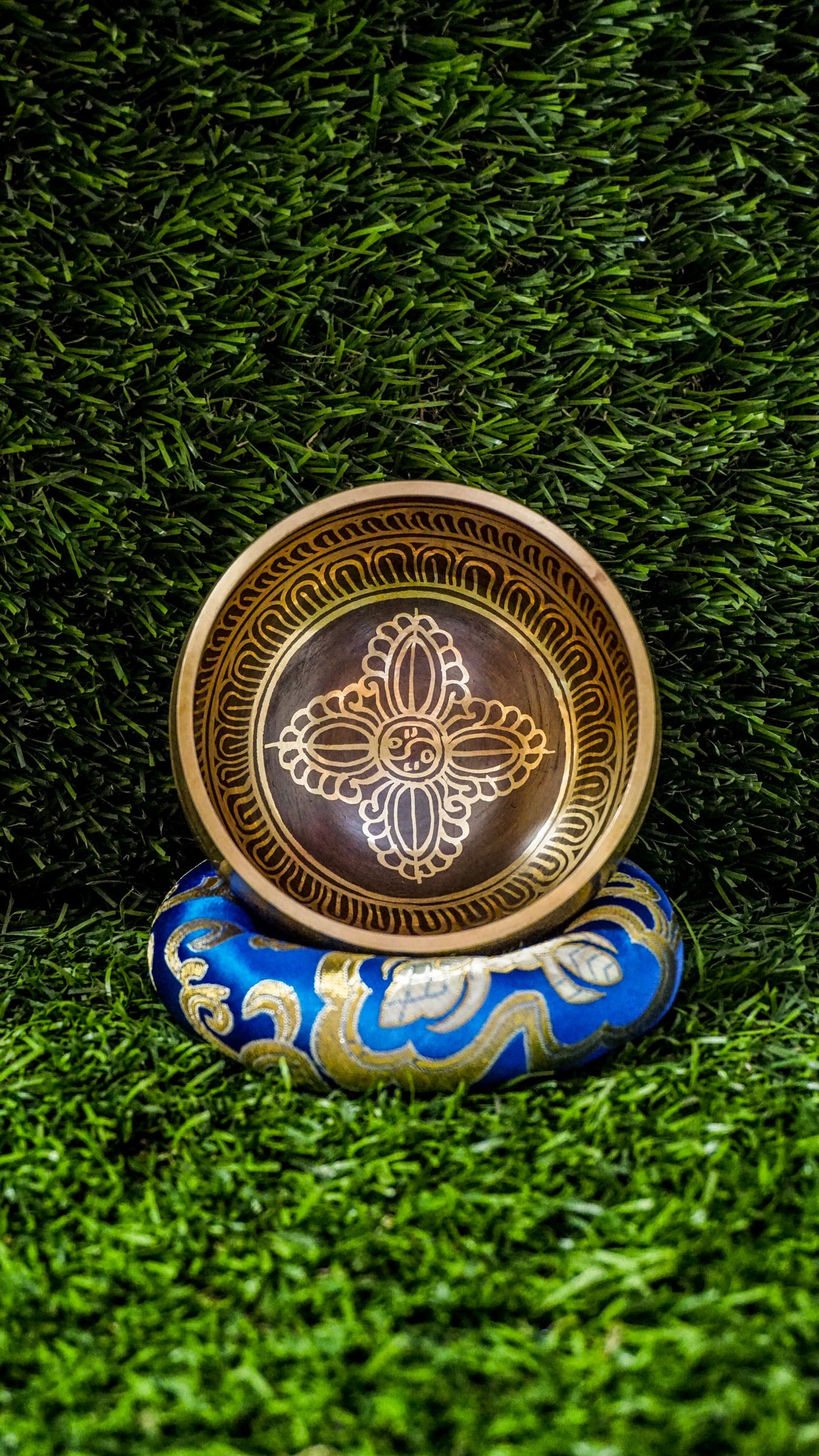 The Double Dorje Singing Bowl grounds and centers your energy. At its heart is the double dorje symbol, representing protection, balance, and spiritual strength. The outside is wrapped with the Om Mani Padme Hum mantra, adding compassion and focus. It produces deep, steady tones perfect for grounding meditation or creating calm. Includes singing bowl, wooden mallet, and silk cushion. Wipe clean and store dry. Let this bowl be your anchor for stillness and strength.