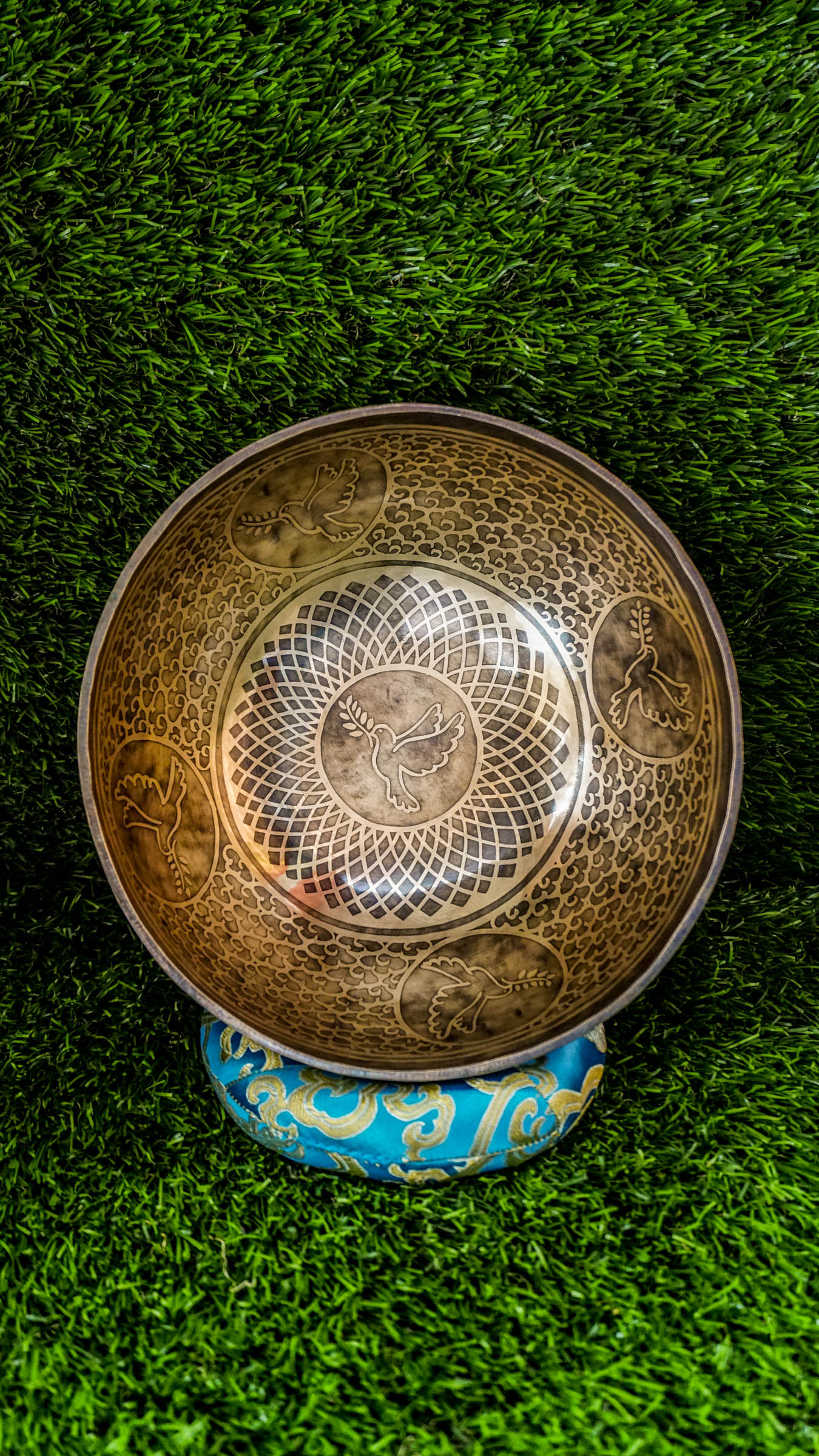The Dove Singing Bowl invites peace, hope, and new beginnings. A graceful dove rests at the center within a geometric flower pattern, symbolizing harmony and compassion. Dove figures surround the inside while lotus and dove motifs decorate the outside, enhancing its peaceful energy. When played, it produces a warm, steady sound that calms the mind and opens the heart. Includes wooden mallet and silk cushion. Perfect for meditation and mindfulness.
