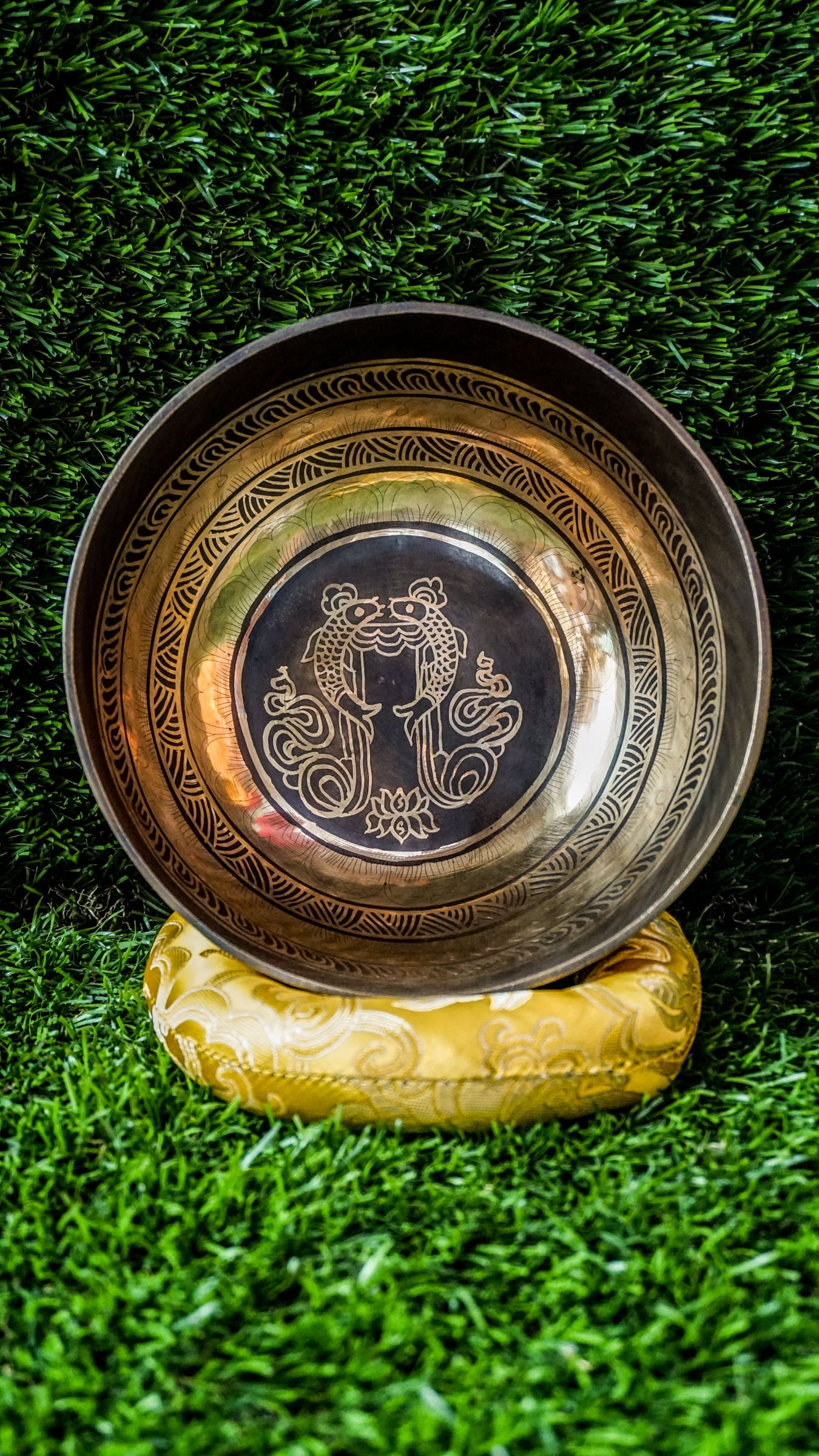 The Two Fish and Lotus Singing Bowl symbolizes harmony and growth. Inside, two fish face each other with a lotus beneath. The outside shows the Om Mani Padme Hum mantra in Tibetan. Its clear, calming tones support meditation and relaxation. Perfect for creating peace and balance in any space.