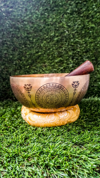 The Kalachakra Mandala Singing Bowl holds the energy of transformation and inner balance. At its center, a human figure with seven chakras is framed by the Kalachakra Mandala’s four gates, symbolizing openness to wisdom. Flower-like mandala patterns fill the inside and outside, creating a peaceful and sacred presence. Its deep, grounding sound helps calm the mind and support focused meditation.