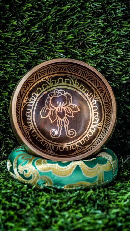 The lotus singing bowl features a lotus flower at its center, symbolizing purity and spiritual growth. The sacred mantra Om Mani Padme Hum flows around the outside in Tibetan script, enhancing its calming energy. Its clear, soothing tones create a peaceful atmosphere for meditation or relaxation