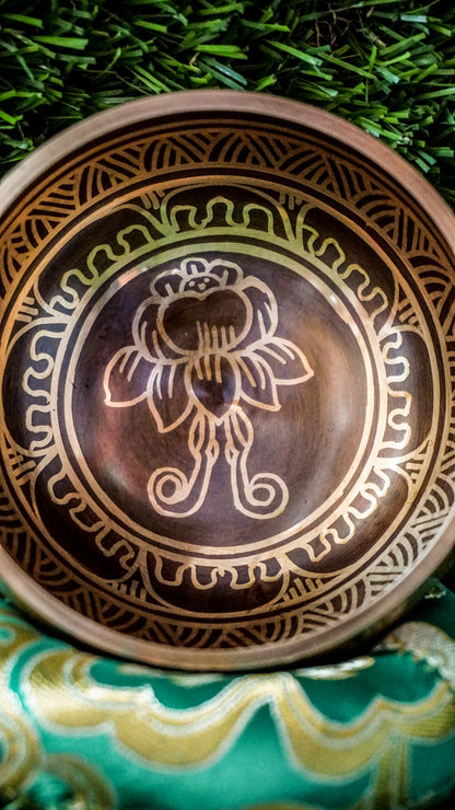 The lotus singing bowl features a lotus flower at its center, symbolizing purity and spiritual growth. The sacred mantra Om Mani Padme Hum flows around the outside in Tibetan script, enhancing its calming energy. Its clear, soothing tones create a peaceful atmosphere for meditation or relaxation