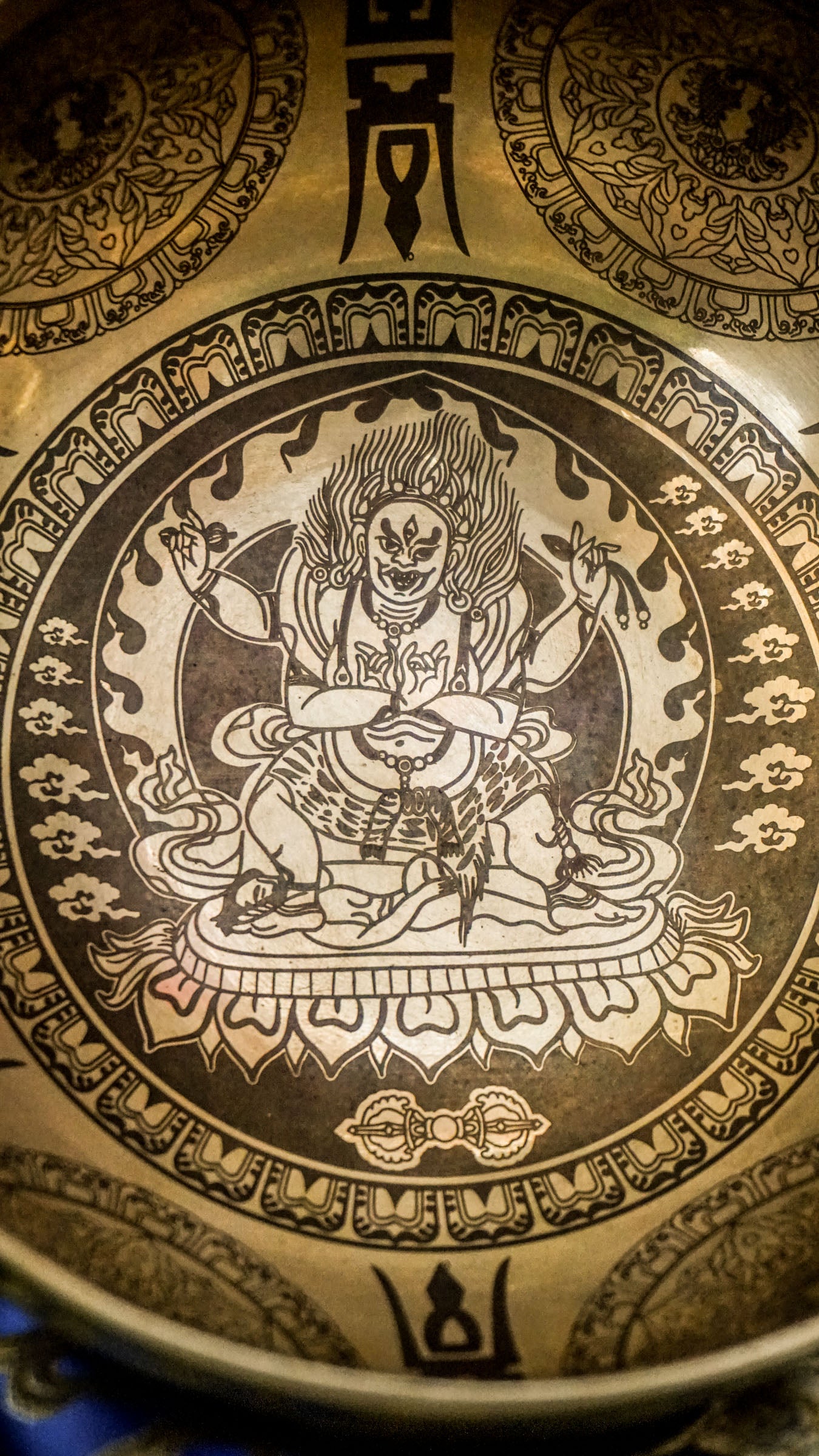 Invite protection, strength, and transformation with our handcrafted Mahakala Singing Bowl. Featuring a finely engraved image of Mahakala inside, it symbolizes fearless guardianship and obstacle removal. The exterior is adorned with protective motifs to deepen its sacred energy. Handmade by skilled artisans, this bowl produces deep, grounding tones that support meditation and spiritual empowerment. Includes a wooden mallet and silk cushion for easy use and care.