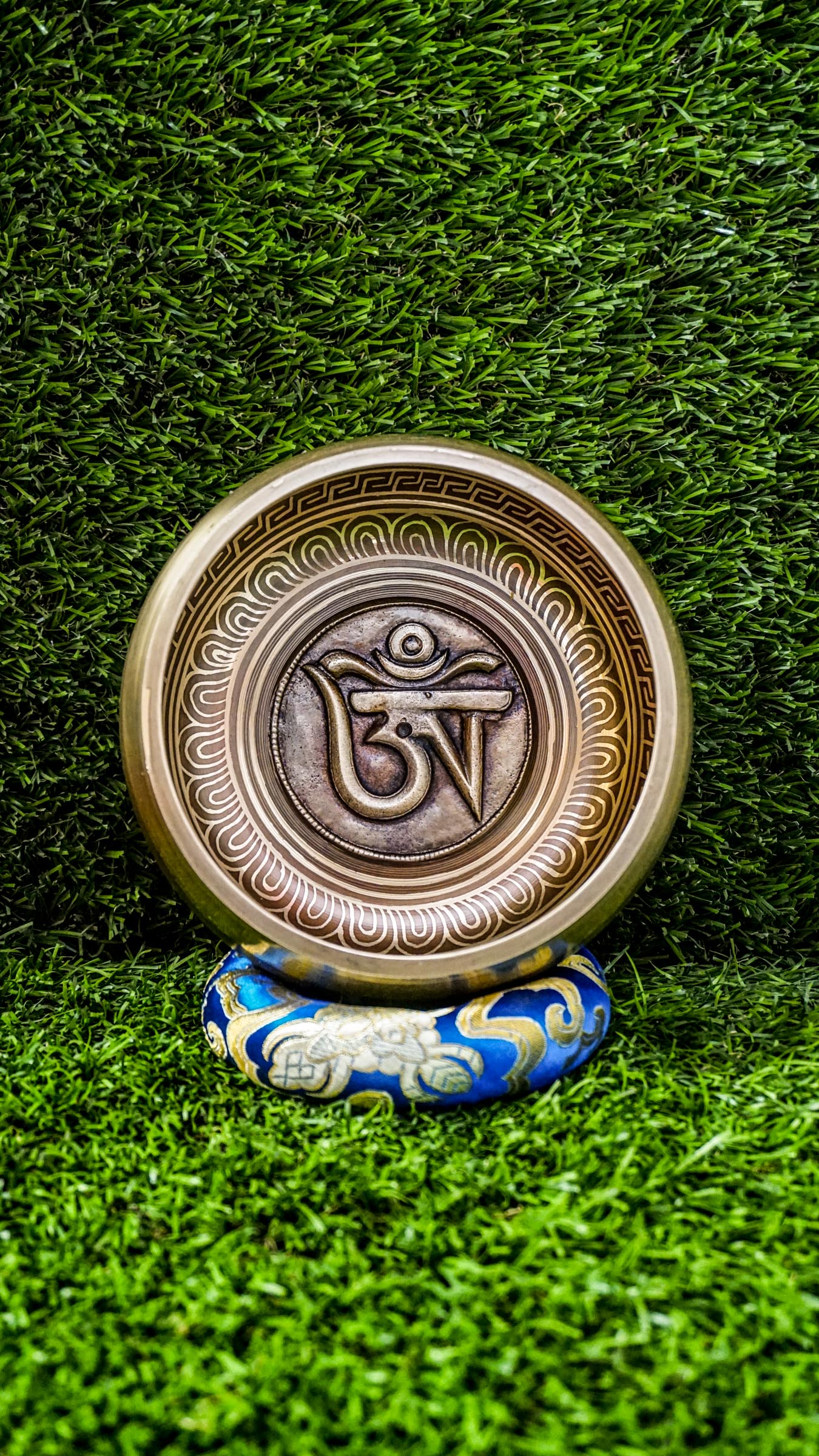 The Om Singing Bowl features a carved Tibetan Om symbol inside and the Om Mani Padme Hum mantra outside. Its clear, calming tone supports meditation and peace. Includes mallet and cushion. Wipe gently and store dry.