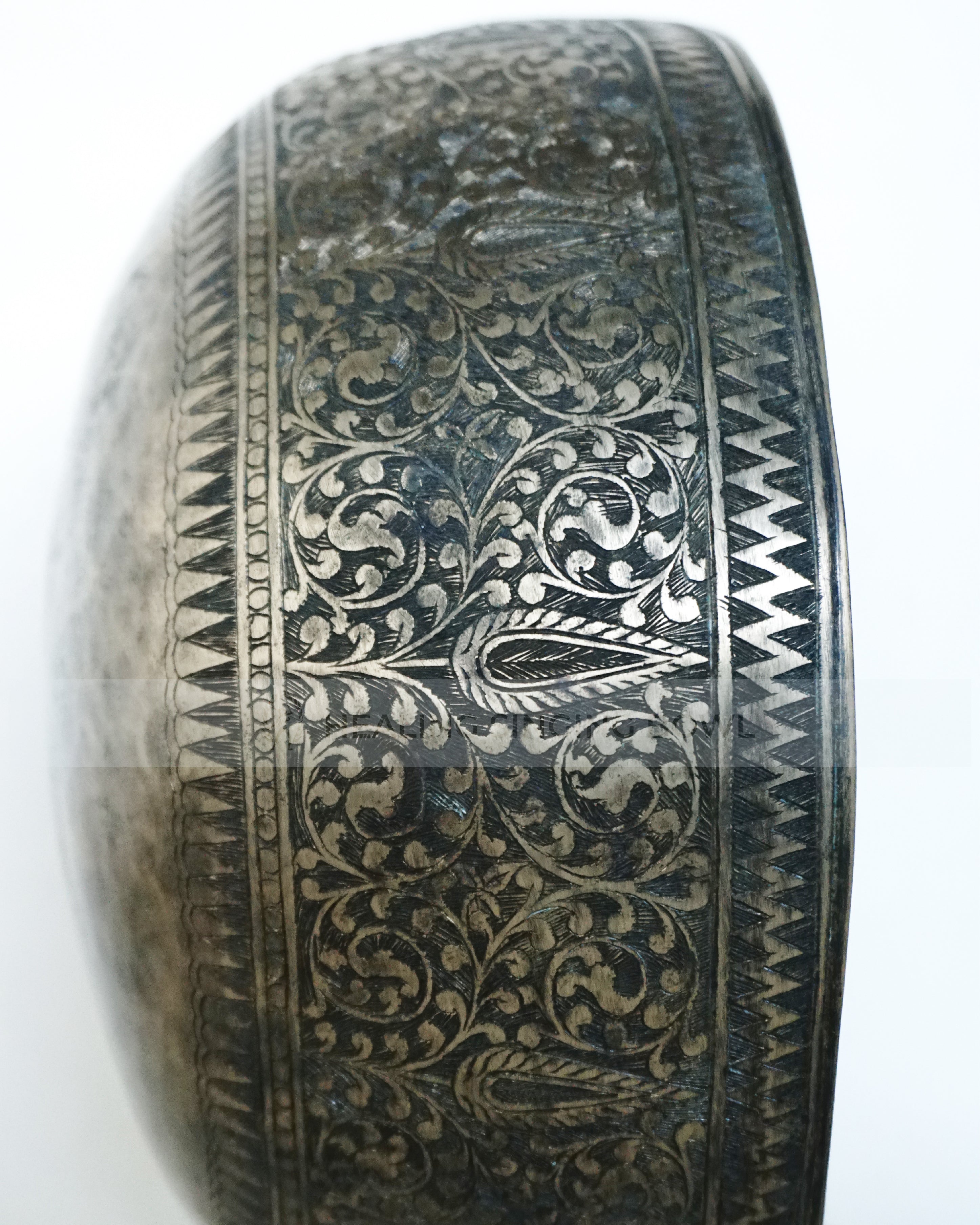 Large hand-hammered Tibetan singing bowl with a 24.5 cm diameter, shown from the top view and placed on a decorative cushion against a white background.