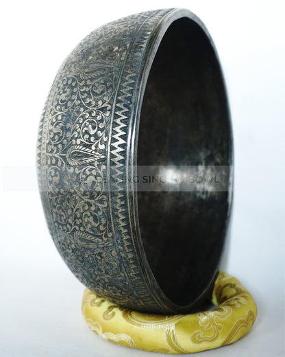 Large hand-hammered Tibetan singing bowl with a 24.5 cm diameter, shown from the top view and placed on a decorative cushion against a white background.