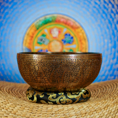 Semi antique floral engraved Tibetan singing bowl handcrafted in Nepal with detailed botanical patterns and antique bronze finish