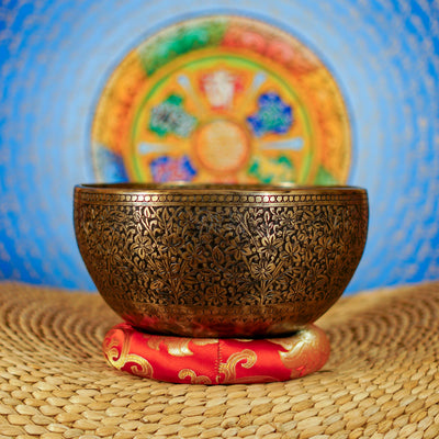 Semi antique floral engraved singing bowl with intricate flower and leaf patterns and an antique bronze finish