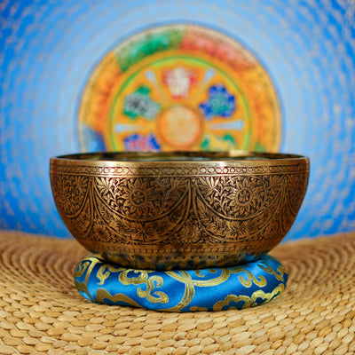 Semi antique singing bowl with intricate floral engraved panels and traditional aged bronze finish