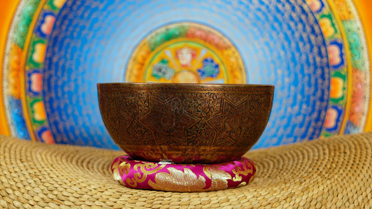 Semi antique singing bowl with intricate star-shaped floral engraving and traditional botanical patterns