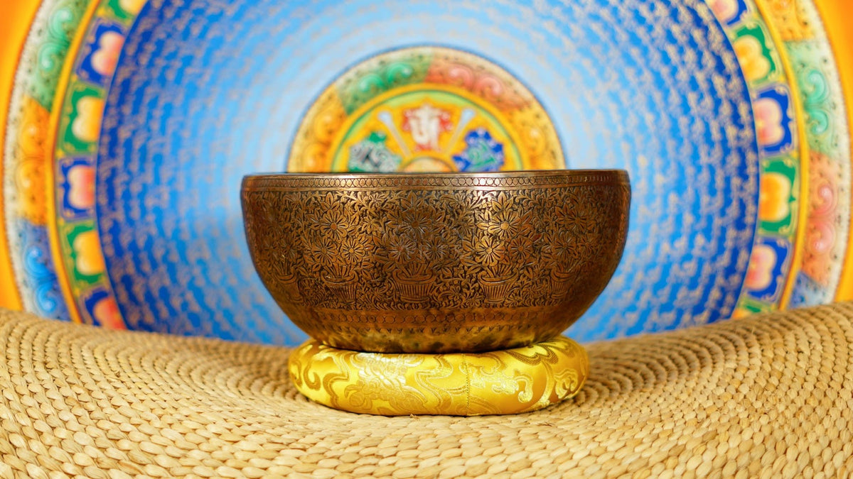 Semi antique handmade singing bowl with intricate flower vase engraving and floral patterns on aged bronze