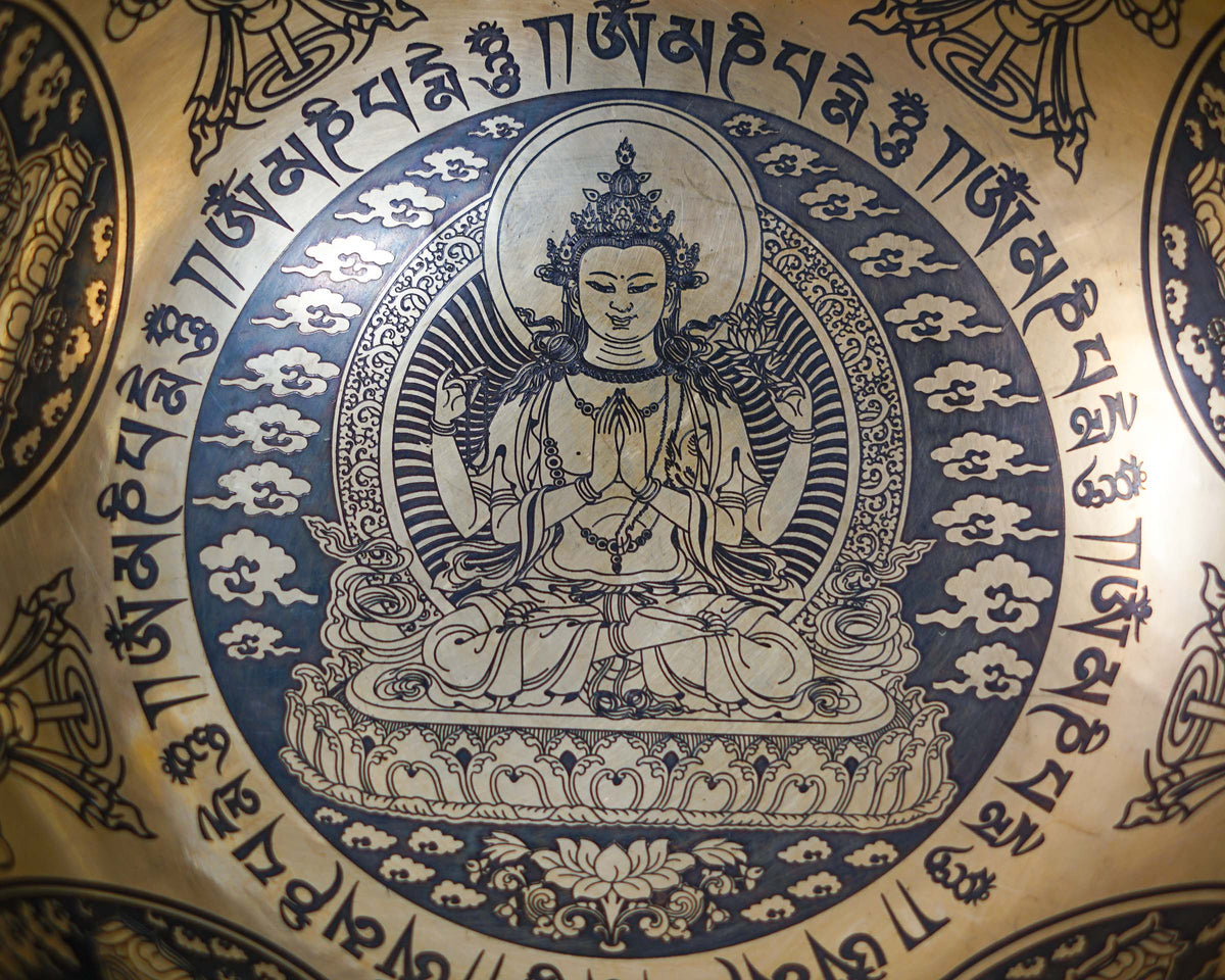 Close up of Chengresi Bodhisattva of Compassion engraved inside a golden bronze tone singing bowl