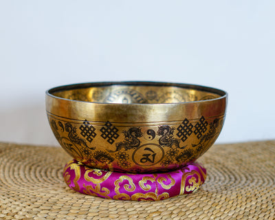 Green Tara singing bowl displaying engraved auspicious knots and traditional decorative motifs on the exterior