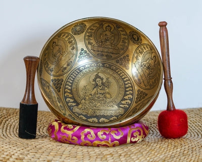 Green Tara singing bowl showing engraved dragons, auspicious knots, and traditional Himalayan decorative motifs on the exterior