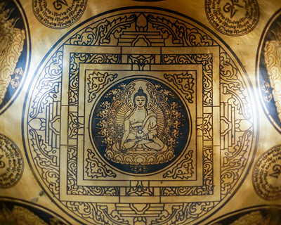 Close up of Buddha seated on a lotus throne inside an engraved geometric mandala on a golden bronze tone singing bowl