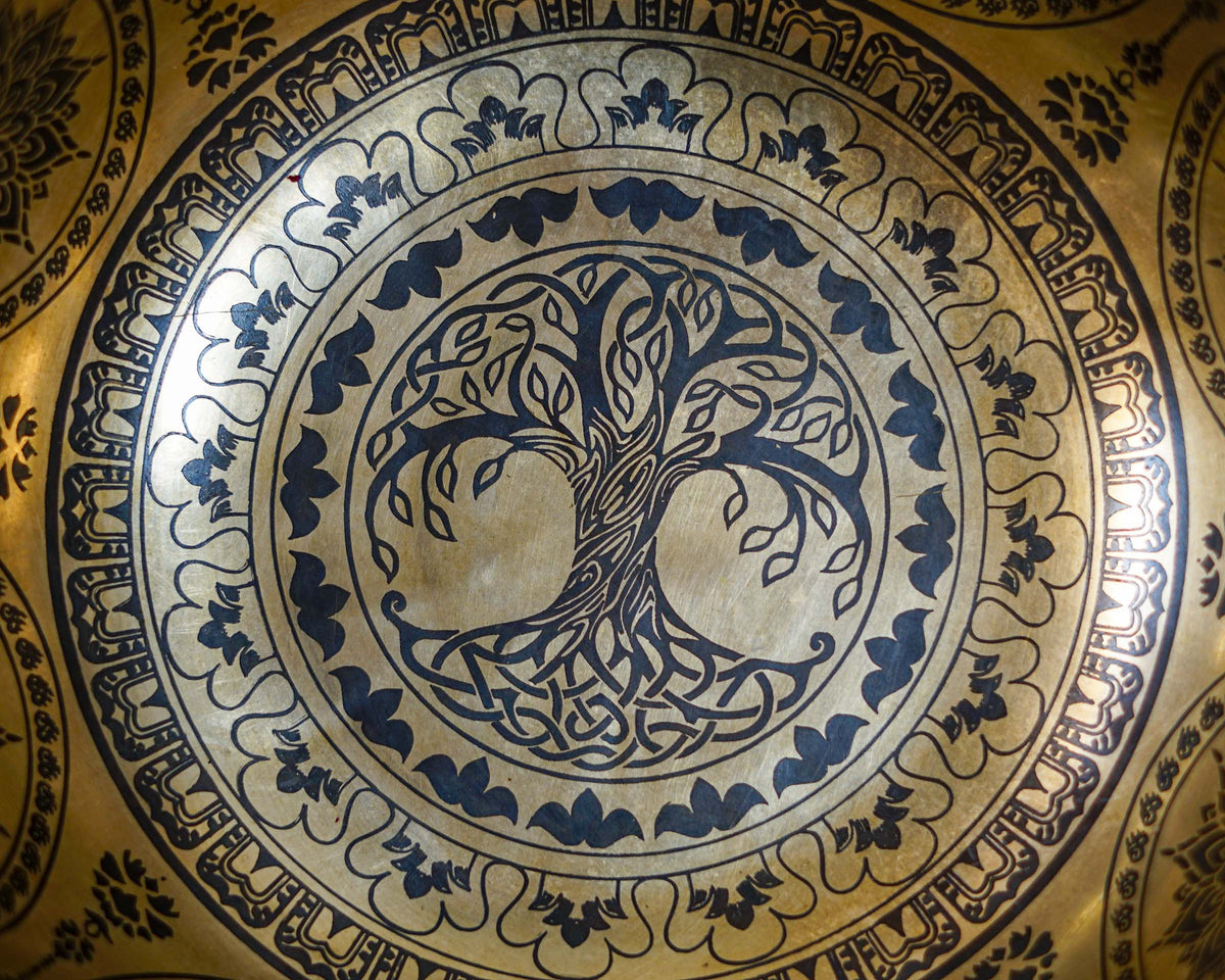 Close up of the Tree of Life engraving inside a golden toned singing bowl.