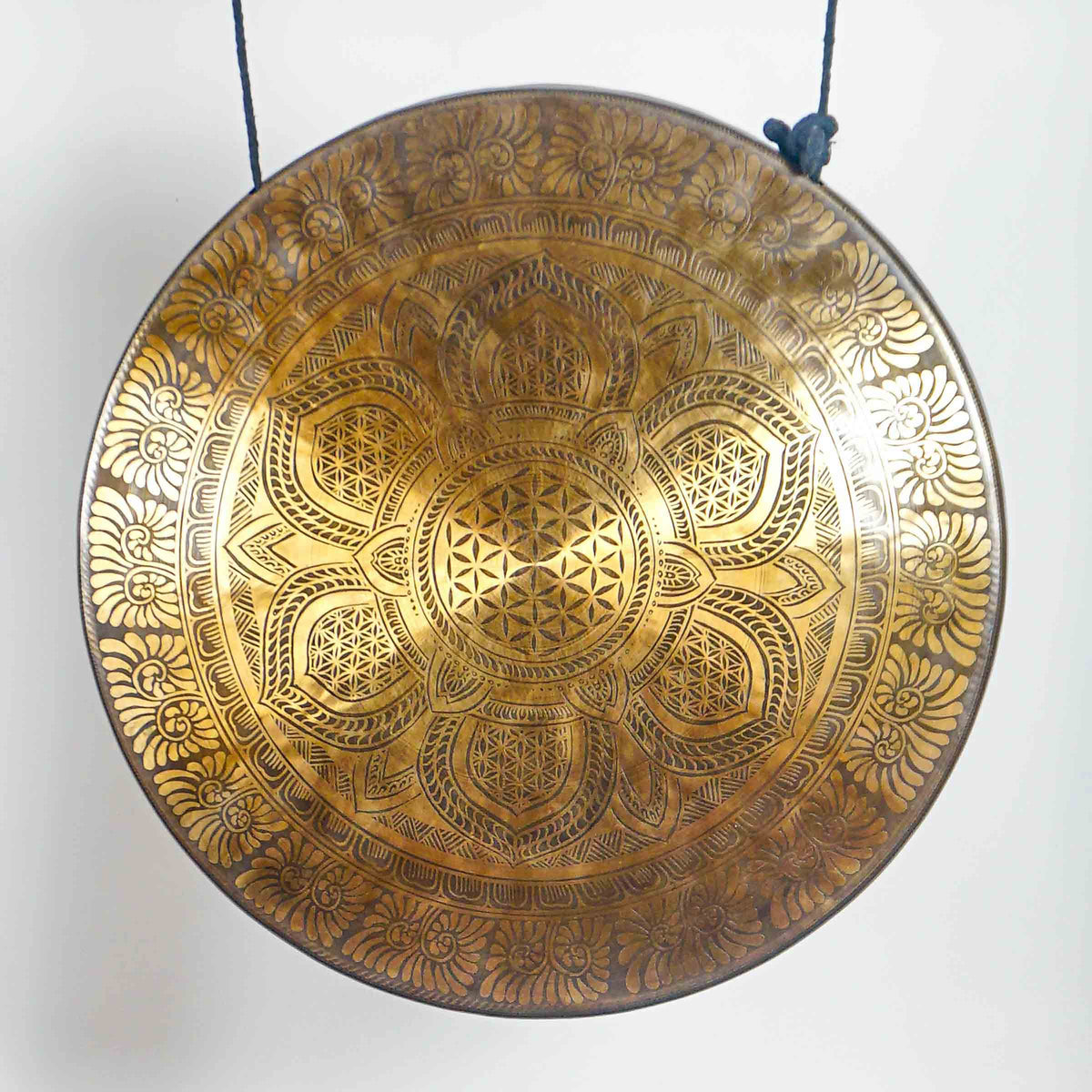 Front view of a circular antique-bronze gong displaying detailed lotus petals, sacred geometry and floral engraved borders.