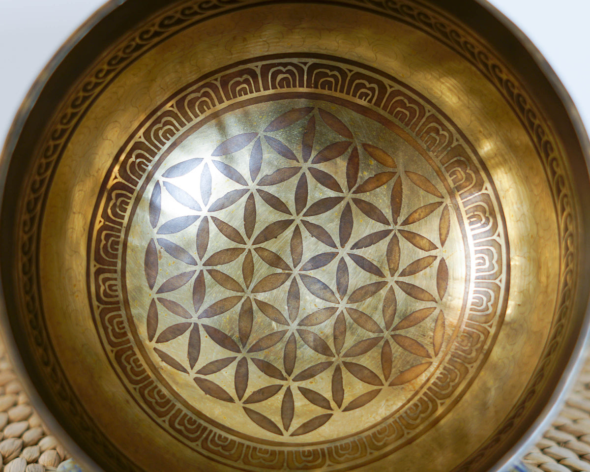 Close up of the Flower of Life sacred geometry engraving inside an antique gold Tibetan singing bowl.
