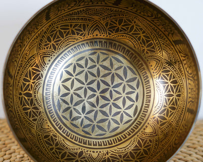 Close up of the Flower of Life sacred geometry engraved inside a golden Tibetan singing bowl.