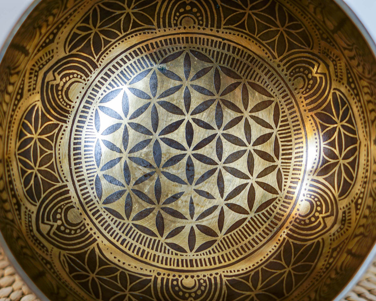 Close up of the Flower of Life geometric pattern engraved inside a golden Tibetan singing bowl.