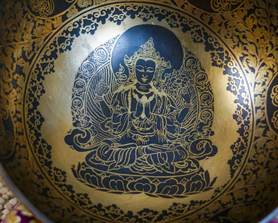 Close up of Chengresi seated on a lotus throne engraved inside a golden Tibetan singing bowl with intricate floral patterns.