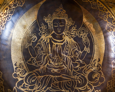 Close up of Chengresi engraved inside a golden Tibetan singing bowl with intricate floral borders and dark bronze detailing.