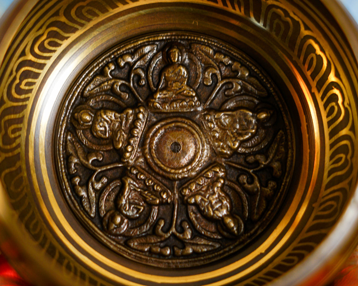 Close-up of Pancha Buddha singing bowl showing the detailed Five Buddhas design inside