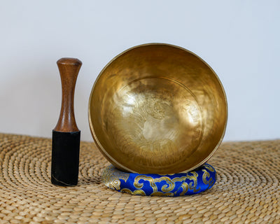 Close up of a detailed hand-engraved tiger motif with fine stippling inside a golden bronze Tibetan singing bowl.