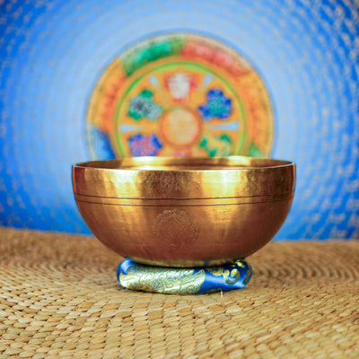 Side view of handcrafted Milarepa singing bowl showing antique golden metal finish