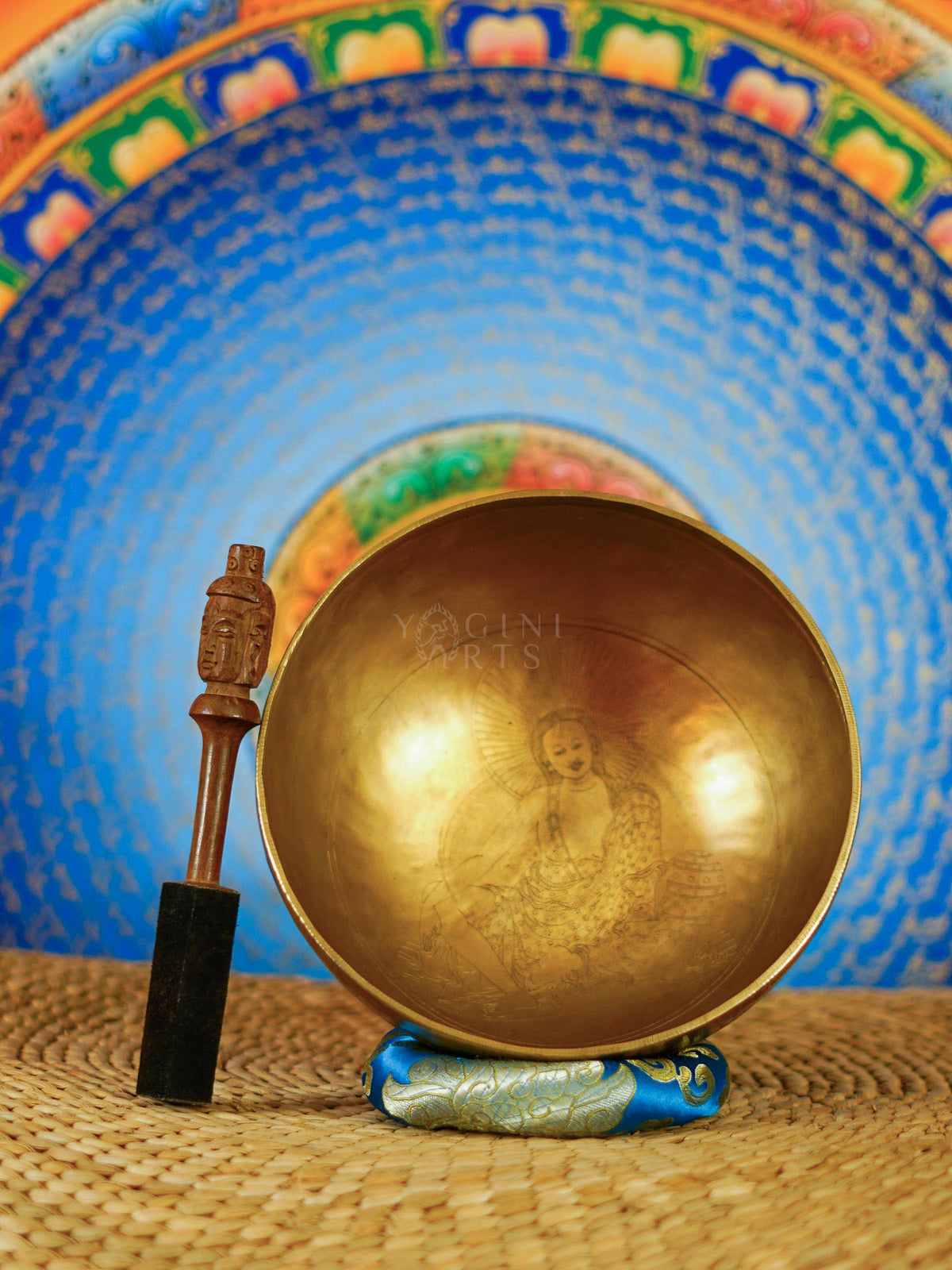Milarepa engraved Tibetan singing bowl with wooden mallet and blue decorative cushion