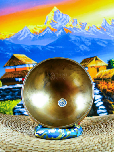Himalayan singing bowl set displayed with wooden mallets and decorative cushions for meditation and sound practice.
