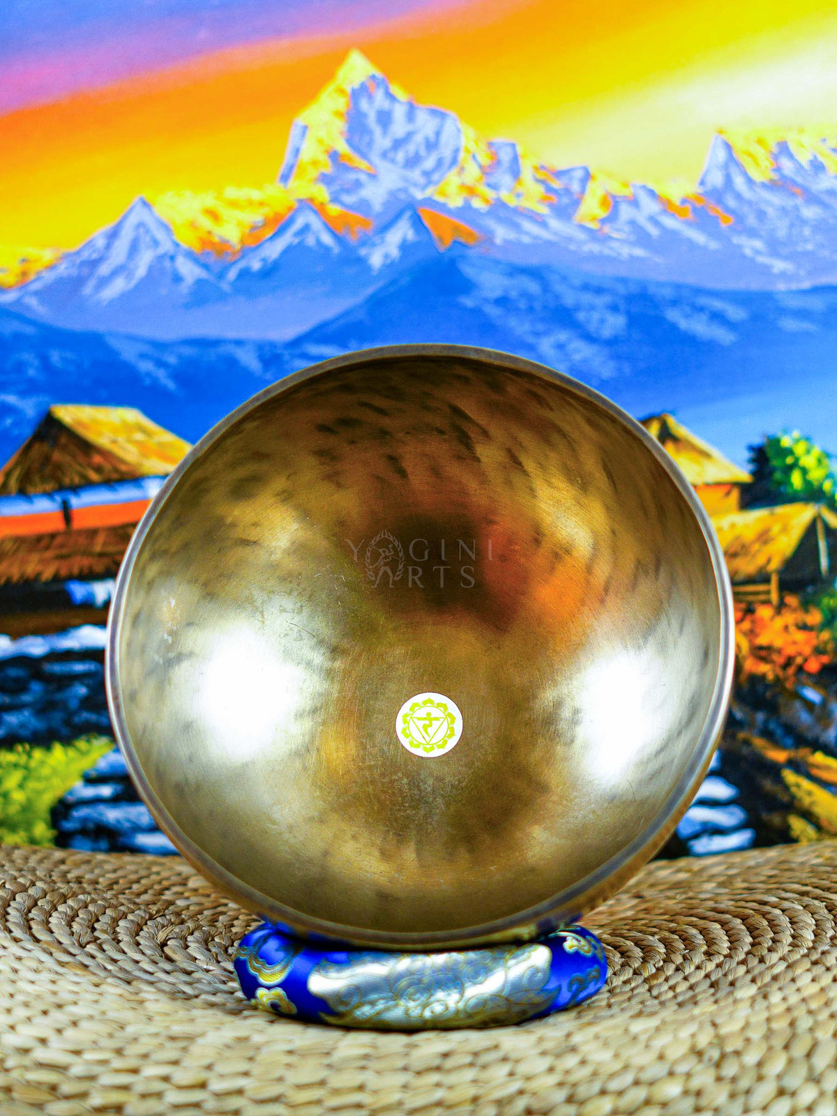 Himalayan singing bowl set displayed with wooden mallets and decorative cushions for meditation and sound practice.