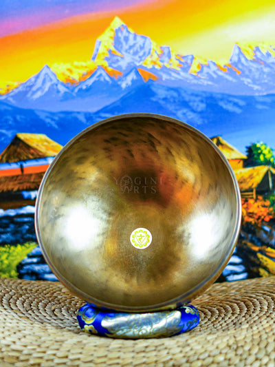 Himalayan singing bowl set displayed with wooden mallets and decorative cushions for meditation and sound practice.