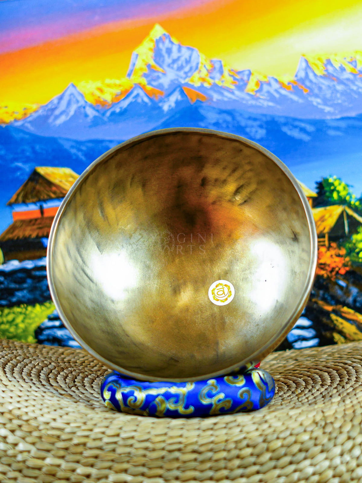 Himalayan singing bowl set displayed with wooden mallets and decorative cushions for meditation and sound practice.